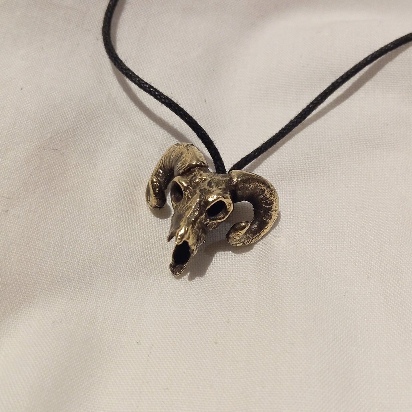 Colgante de cráneo de cabra en bronce