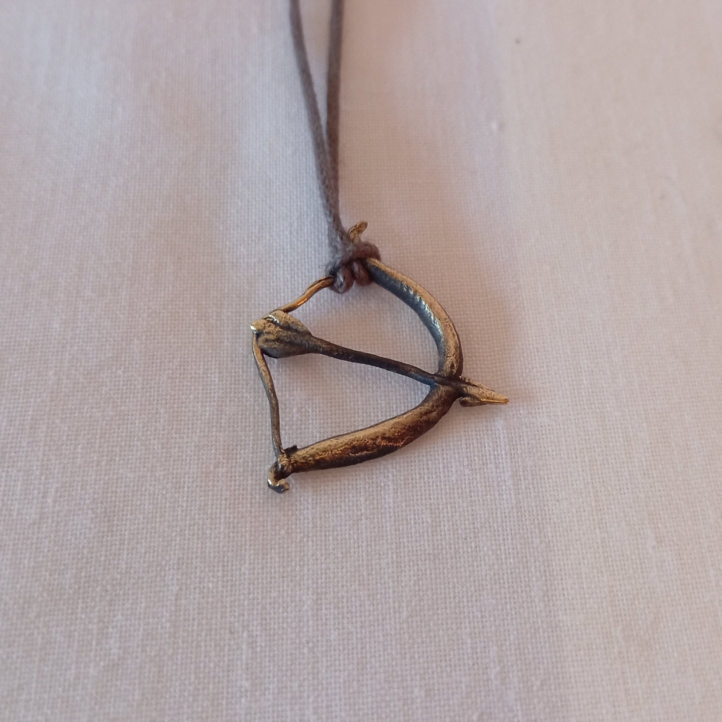 Colgante de arco flecha en bronce